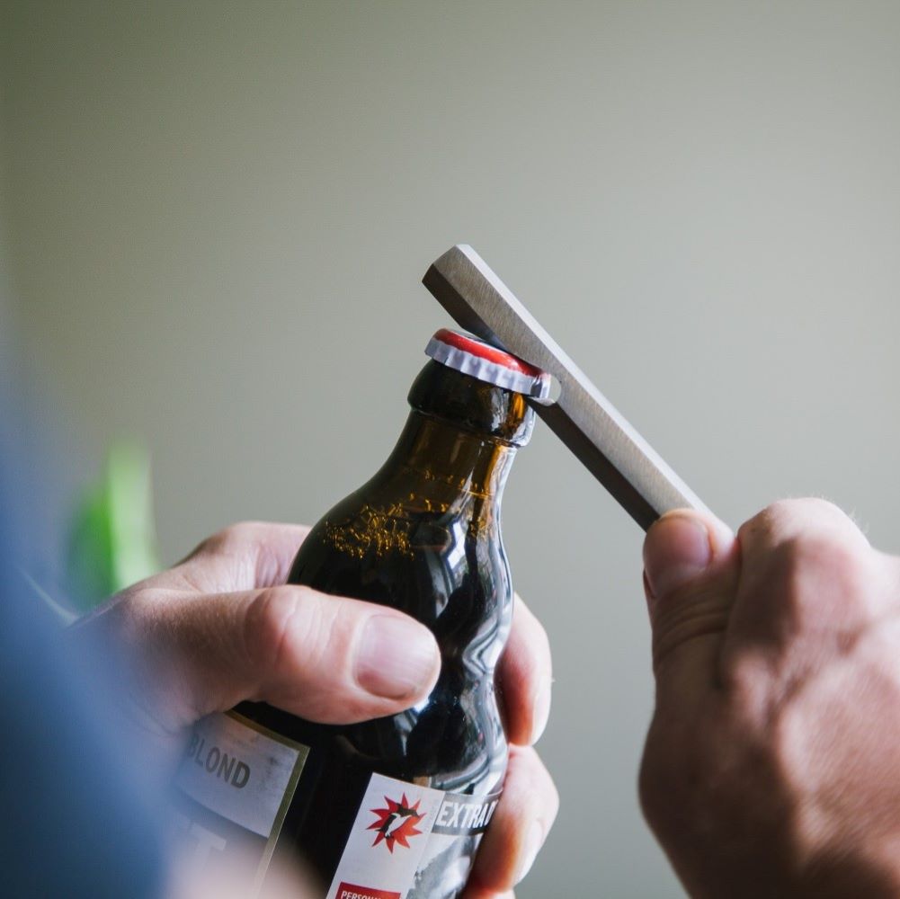 Bottle opener with leather sleeve